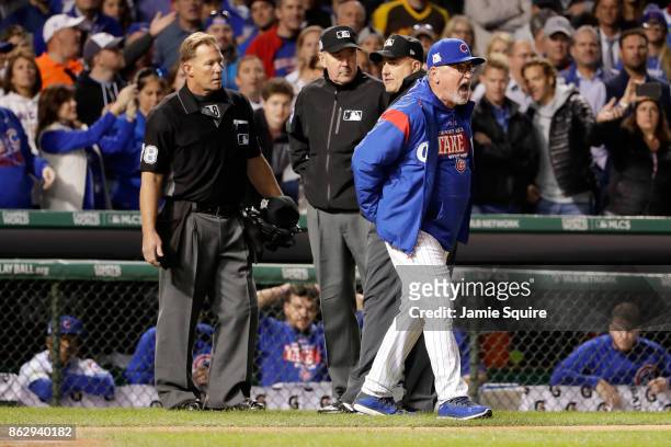 Manager Joe Maddon of the Chicago Cubs argues an overturned call with umpires and is ejected in the eighth inning during game four of the National...