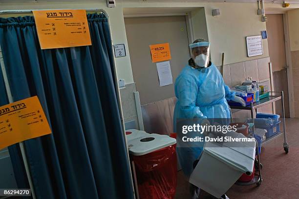 An Israeli cleaning woman dressed in protective clothing removes contaminated trash from an isolation ward in Meir Hospital where a 47-year-old man...
