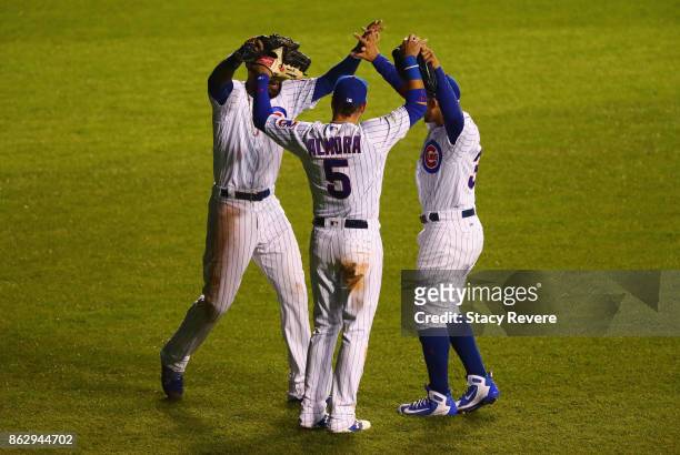 Jason Heyward, Albert Almora Jr. #5, and Jon Jay of the Chicago Cubs celebrate after beating the Los Angeles Dodgers 3-2 in game four of the National...
