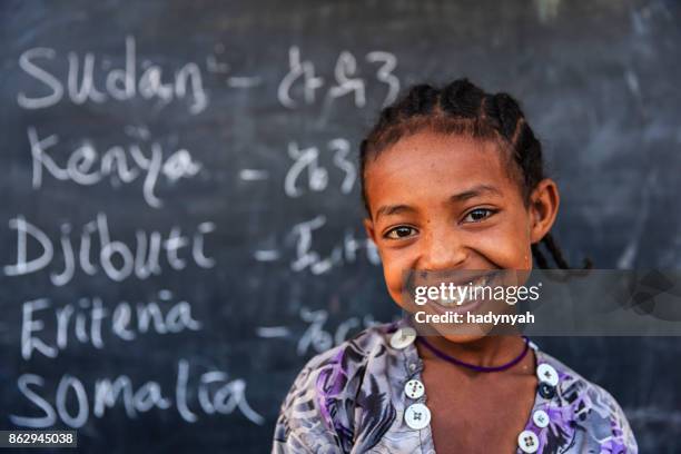 afrikaanse meisje is het leren van engels - african school kids stockfoto's en -beelden