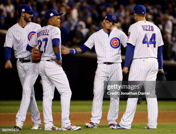 Kris Bryant, Addison Russell, Javier Baez, and Anthony Rizzo of the Chicago Cubs meet during a pitching change in the seventh inning against the Los...
