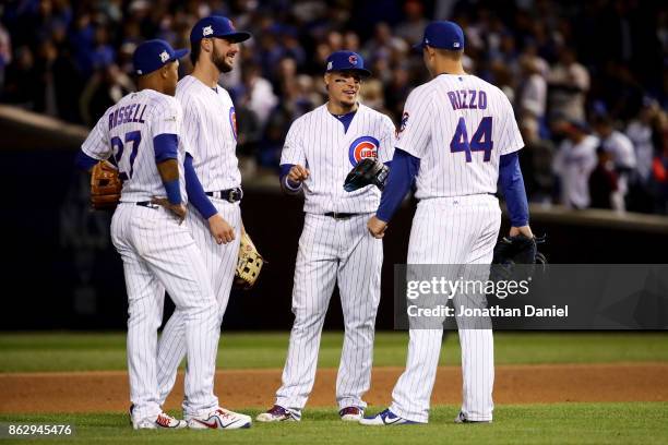 Kris Bryant, Addison Russell, Javier Baez, and Anthony Rizzo of the Chicago Cubs meet during a pitching change in the seventh inning against the Los...