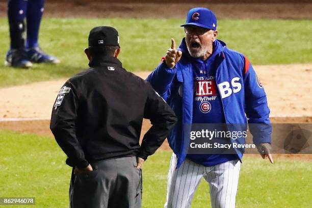 Manager Joe Maddon of the Chicago Cubs argues a call with umpire Alfonso Marquez in the eighth inning against the Los Angeles Dodgers during game...