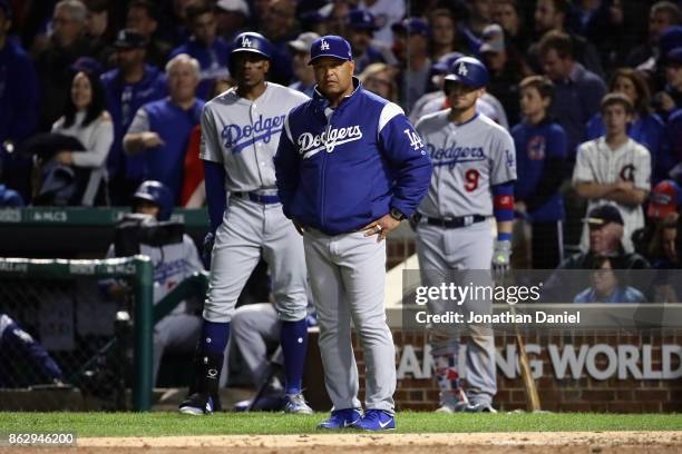 Manager Dave Roberts of the Los Angeles Dodgers looks on during a stoppage in play in the eighth inning against the Chicago Cubs during game four of...