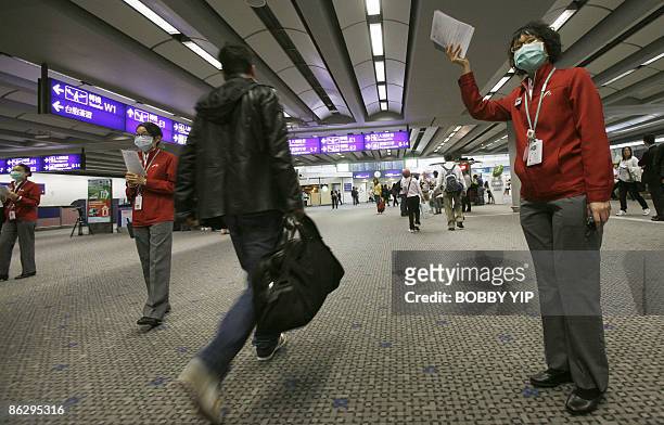 Contract staff of the Port Health department at the Hong Kong Airport ask passengers to fill in health declaration forms on arrival in Hong Kong on...