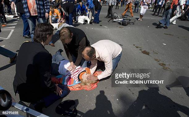Victim is helped after a car crashed into the crowd waiting for the visit of the royal family in Apeldoorn on April 30, 2009. Dutch Queen Beatrix and...