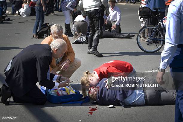 Victim is helped after a car crashed into the crowd waiting for the visit of the royal family in Apeldoorn on April 30, 2009. Dutch Queen Beatrix and...