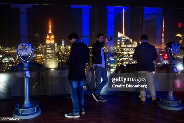 Man takes a selfie photograph as the spires of the Empire State Building, from left, One World Trade Center, 1 Bryant Park and 4 Times Square stand...