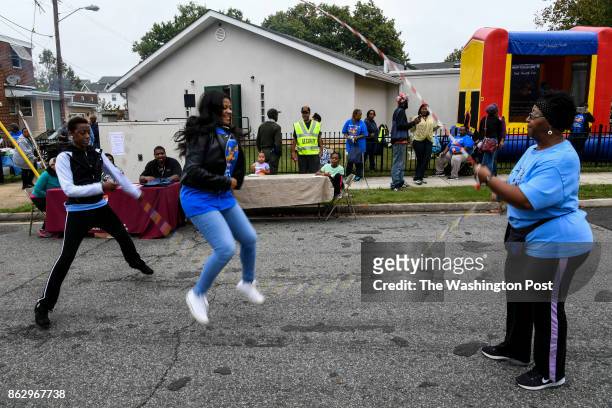 Robbin Ebb, left, and Carlyle Prince, right, of the DC Retro Jumpers teach Double Dutch jump-rope to Shamere Ross during the Open Door Baptist Church...