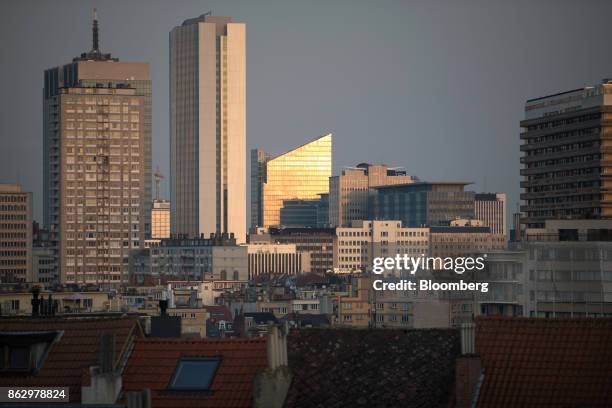 Commercial skyscrapers stand on the city skyline beyond tiled rooftops in the northern quarter business district, top, in Brussels, Belgium, on...