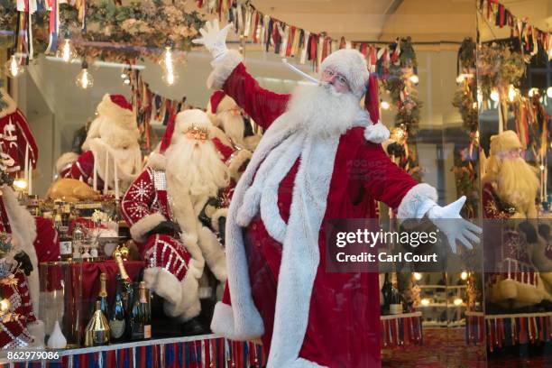 An actor dressed as Santa poses for photographs next to a Christmas window display at Selfridges on October 19, 2017 in London, England. Selfridges...