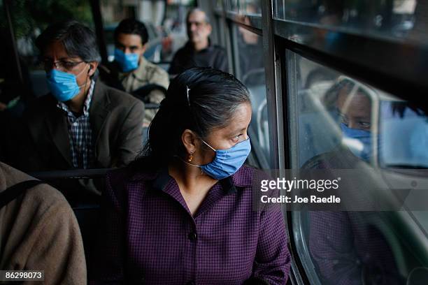People wear surgical masks, to help prevent being infected with the swine flu, as they ride a public bus on April 30, 2009 in Mexico City, Mexico....