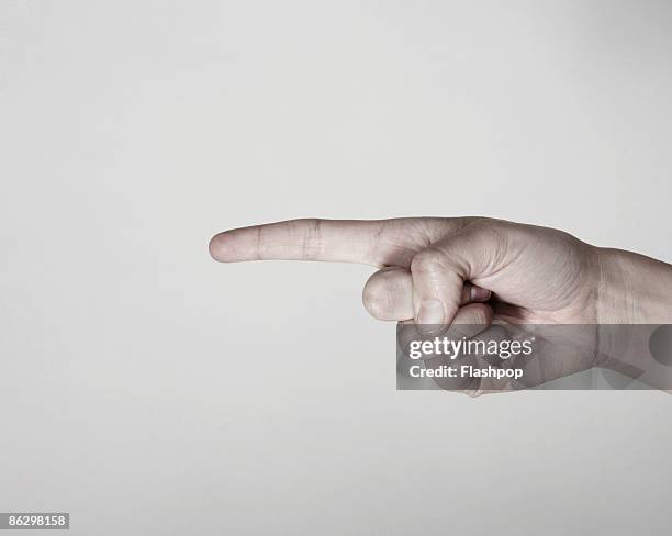 close-up of finger pointing  - finger studio close up stock-fotos und bilder