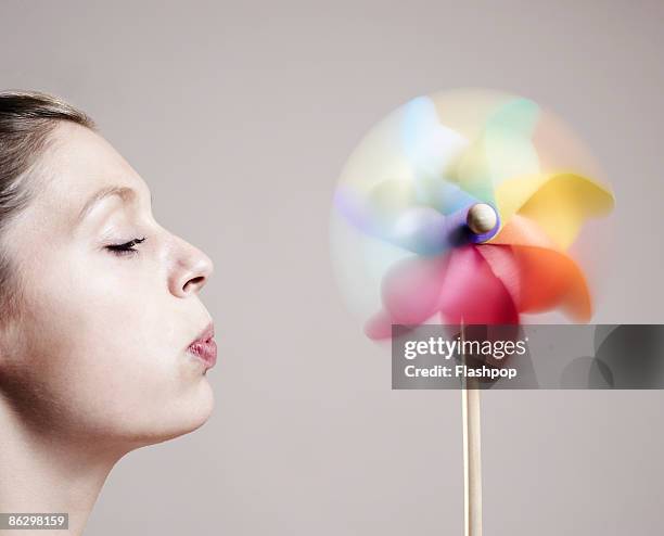 close-up of woman blowing onto a windmill - the whirligig stockfoto's en -beelden