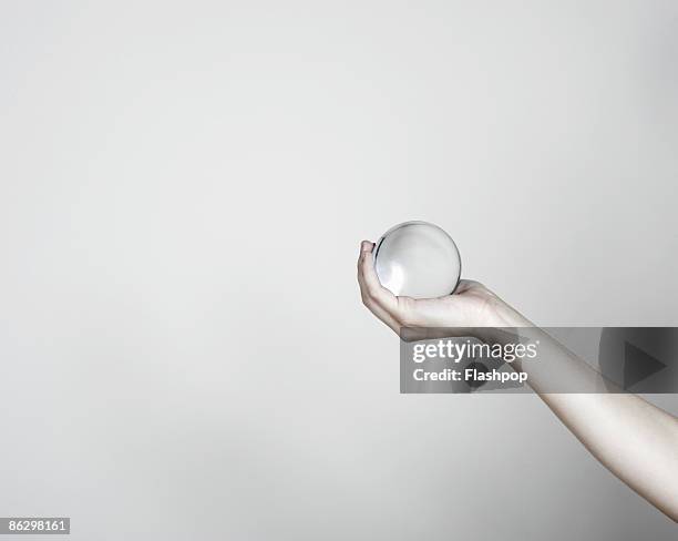 close-up of hand holding a crystal ball - 水晶球 ストックフォトと画像