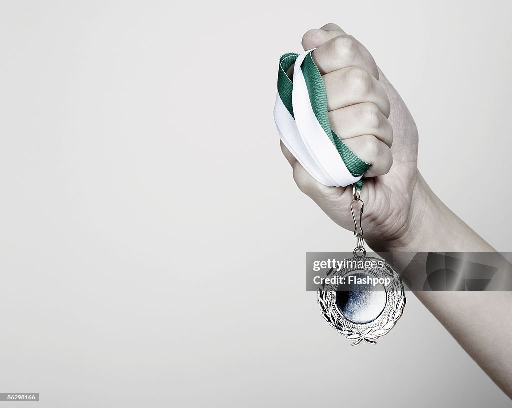 Close-up of hand holding a medal