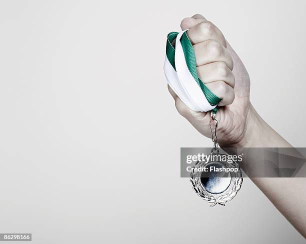 close-up of hand holding a medal - medal stock pictures, royalty-free photos & images