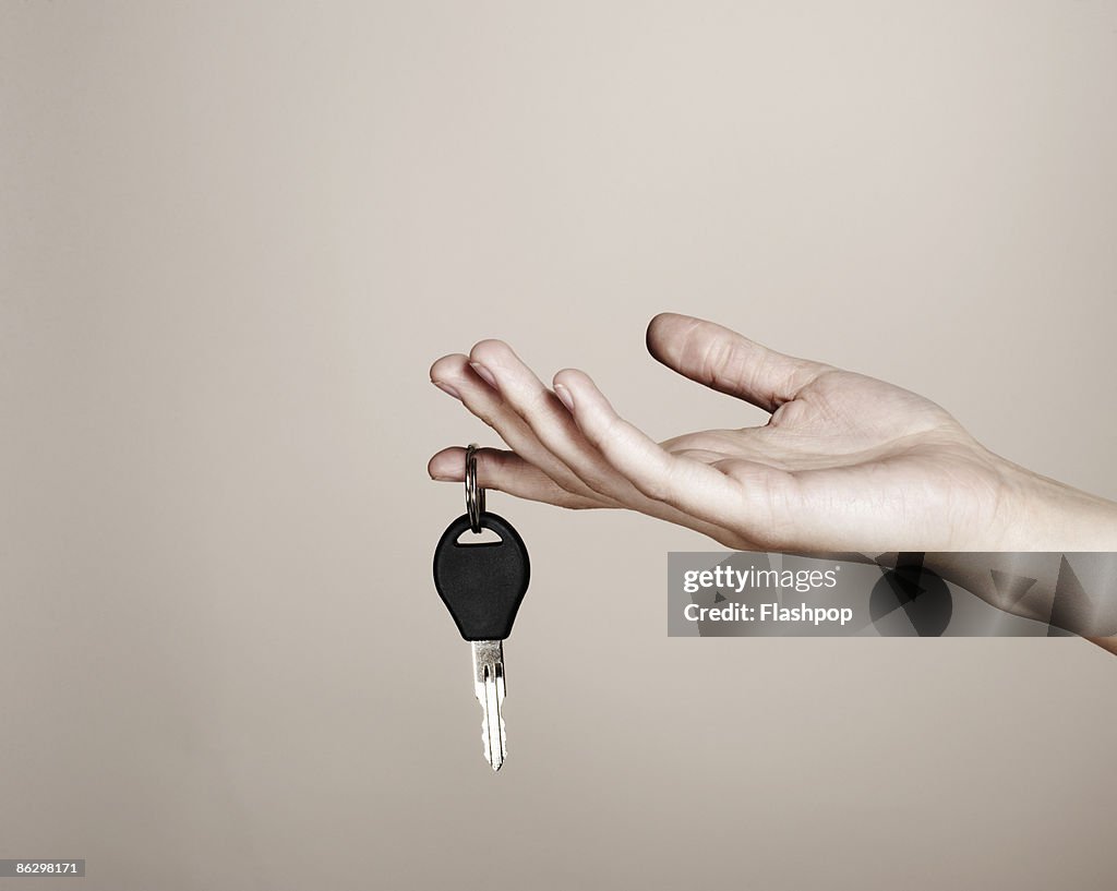 Close-up of hand holding car key