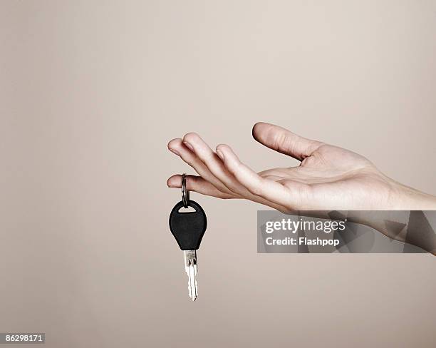close-up of hand holding car key - car keys hand stockfoto's en -beelden