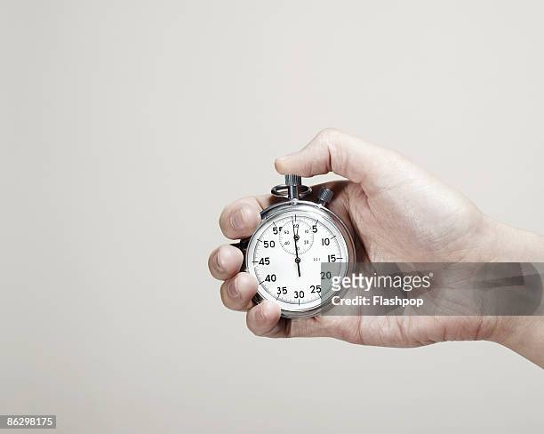 close-up of hand holding a stopwatch  - giorno foto e immagini stock