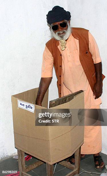 Shri Guru Bharatdasji Darshandasji Maharaj casts his vote at a makeshift cardboard polling booth at Banej, about 20 km from Sasan in Junagadh...