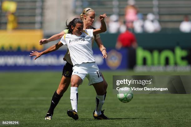 Marta of the Los Angeles Sol shields the ball from Leslie Osborne of FC Gold Pride during the WPS match at The Home Depot Center on April 19, 2009 in...