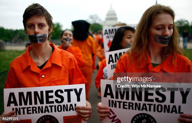 Activists from Amnesty International protest holding signs near the U.S. Capitol on April 30, 2009 in Washington, DC. The protesters were marking...