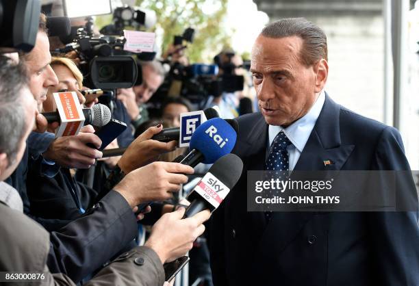 Former Prime Minister and president of Italian right-wing party Forza Italia Silvio Berlusconi speaks to journalists as he arrives at a meeting of...