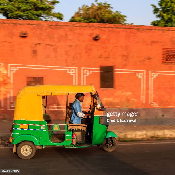 indian man drives auto rickshaw (tuk-tuk), india - auto rickshaw stock pictures, royalty-free photos & images