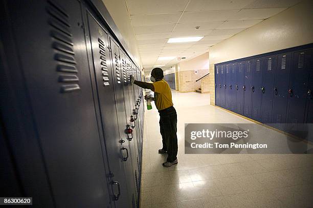 Fort Worth Independent School District custodian Thomas Hanford wipes down lockers with disinfectant in an effort to stop the spread of swine flu at...