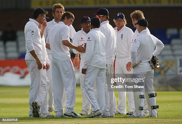 Chris Woakes of England is congratulated by teammates after taking the wicket of Ramnaresh Sarwan of the West Indies during day one of the Tour match...