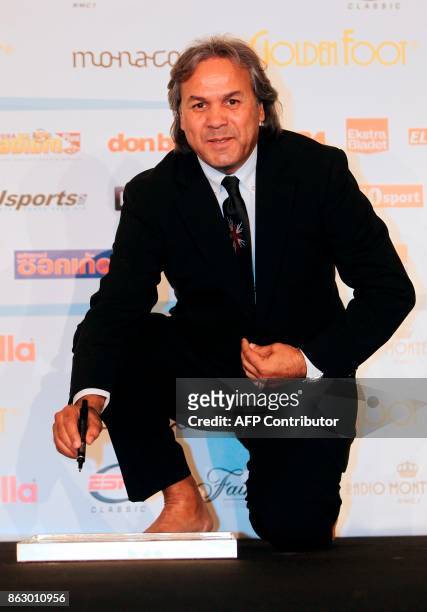 Algeria's former football player Mustapha Rabah Madjer signs his footprint on a slab of moulding compound, on October 10, 2011 in Monaco during the...