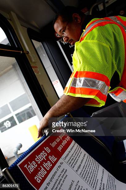 Gerald Irons, an employee of the Washington Metro Area Transit Authority, sprays disinfectant and wipes down the inside of a Metro Bus during a...