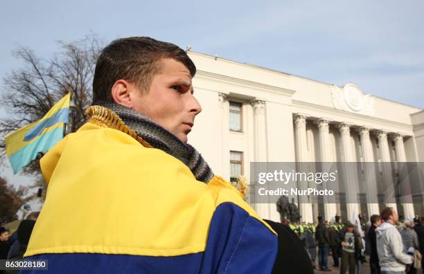 Protester folded in flag is seen in front of Ukrainian Parliament in Kyiv, Ukraine, Oct.19, 2017. Dozens Ukrainians set up a tent camp in front of...