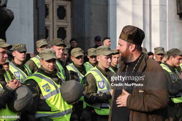 Priest is seen talking to National Guards during a rally in front of Ukrainian Parliament in Kyiv, Ukraine, Oct.19, 2017. Dozens Ukrainians set up a...