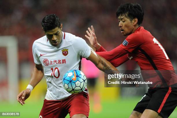 Hulk of Shanghai SIPG and Takuya Aoki of Urawa Red Diamonds compete for the ball during the AFC Champions League semi final second leg match between...