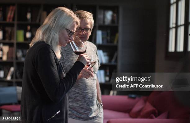 German tourists Susann and Rainer Schmidt taste wine on October 3, 2017 at the Sensory and Multimedia Wine Museum of Bolgheri and of Tuscanys Coast ....