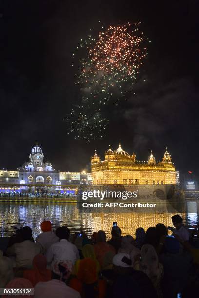 Indian Sikh devotees watch fireworks as they mark Bandi Chhor Divas, or Diwali, at the Golden Temple in Amritsar on October 19, 2017. Sikhs celebrate...
