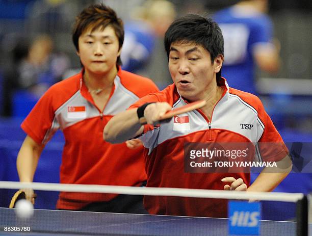 Singapore Gao Ning smashes the ball as his partner Feng Tianwei on during their mixed doubles second round match against Russian Igor Rubtsov and...