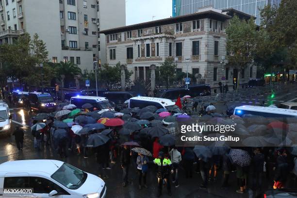 Protesters gather in pouring rain at the building that houses the representation of the Spanish government to demonstrate against the pending...