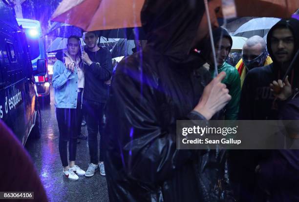 Protesters gather in pouring rain outside the building that houses the representation of the Spanish government to demonstrate against the pending...