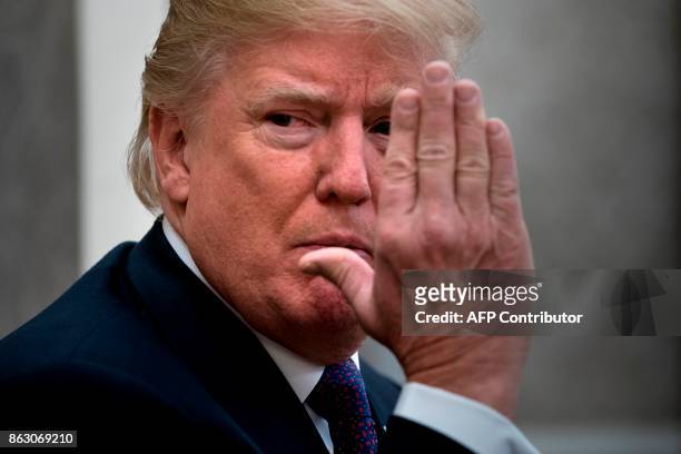President Donald Trump gestures as he pauses while making a statement for the press before a meeting with Governor of Puerto Rico Ricardo Rossello...