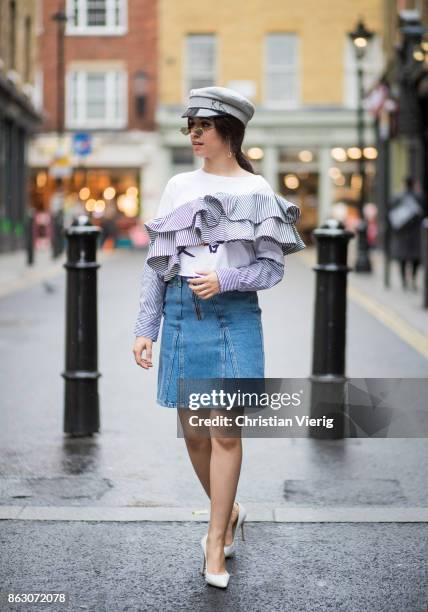 Camila Cabello wearing denim skirt Holzweiler, Dry Clean Only top, military hat Ruslan Baginskiy, Gianvito Rossi pumps is seen on October 19, 2017 in...