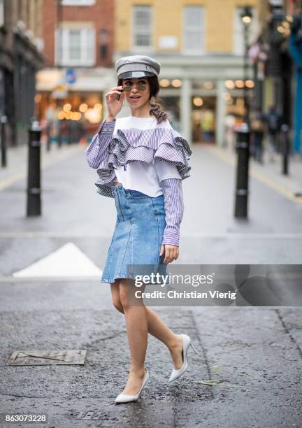 Camila Cabello wearing denim skirt Holzweiler, Dry Clean Only top, military hat Ruslan Baginskiy, Gianvito Rossi pumps is seen on October 19, 2017 in...