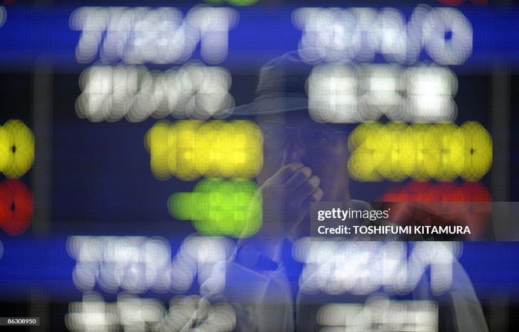 A pedestrian is reflected in a stock ind