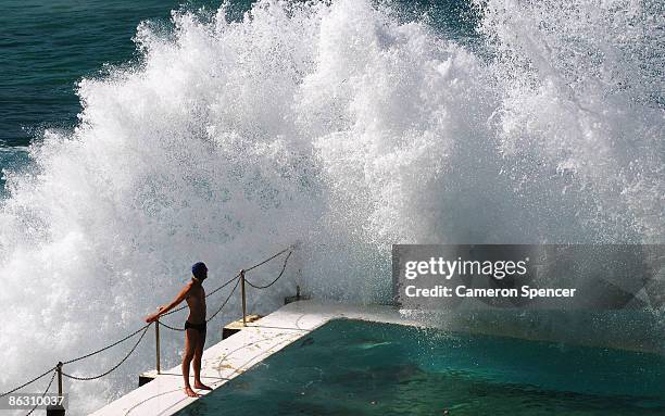 Swimmer watches a wave crash over him as he prepares to dive into the Icebergs ocean pool at Bondi Beach on May 1, 2009 in Sydney, Australia.