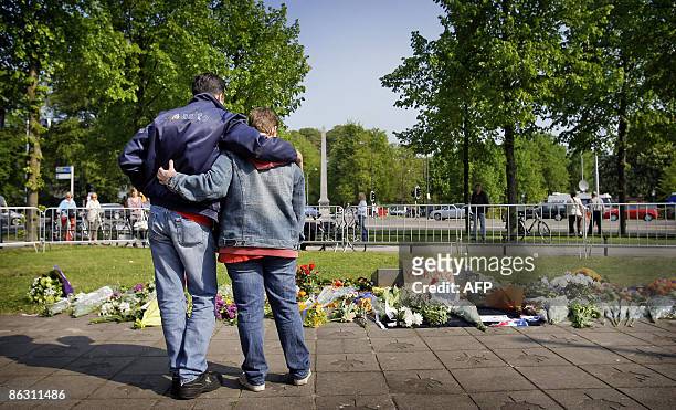 People gather at the war monument in Apeldoorn on May 1, 2009 where a man tried to ram his car into the Dutch royal family, killing five onlookers at...