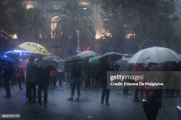 Protesters gather in pouring rain outside the building that houses the representation of the Spanish government to demonstrate against the pending...