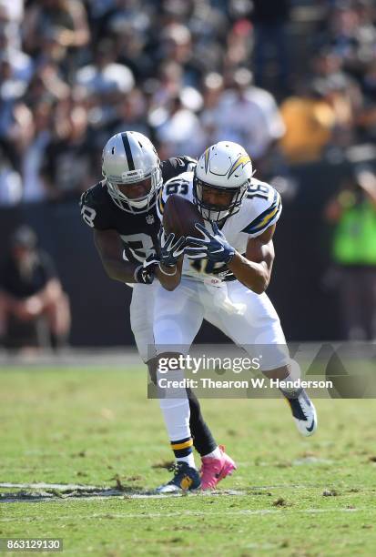 Tyrell Williams of the Los Angeles Chargers catches a pass and gets tackled by T.J. Carrie of the Oakland Raiders during an NFL football game at...