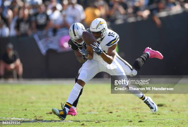 Tyrell Williams of the Los Angeles Chargers catches a pass and gets tackled by T.J. Carrie of the Oakland Raiders during an NFL football game at...